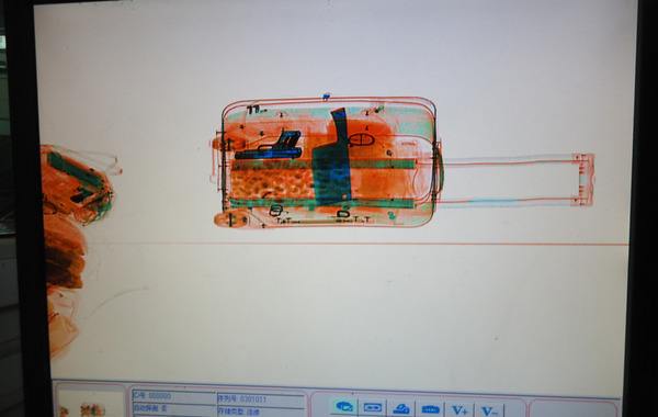 行李箱正在過x光安檢機的成像